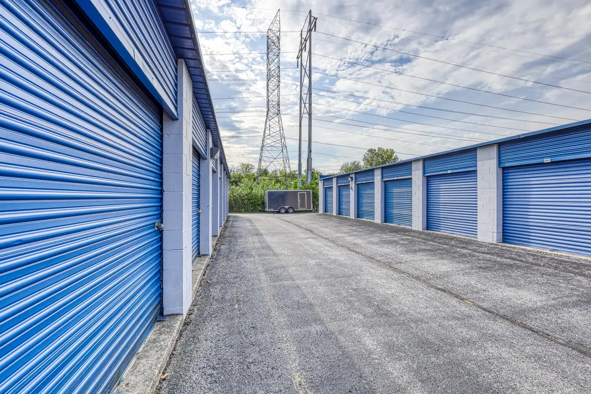 Drive aisle running between rows of blue drive-up storage units at the 10th St facility.