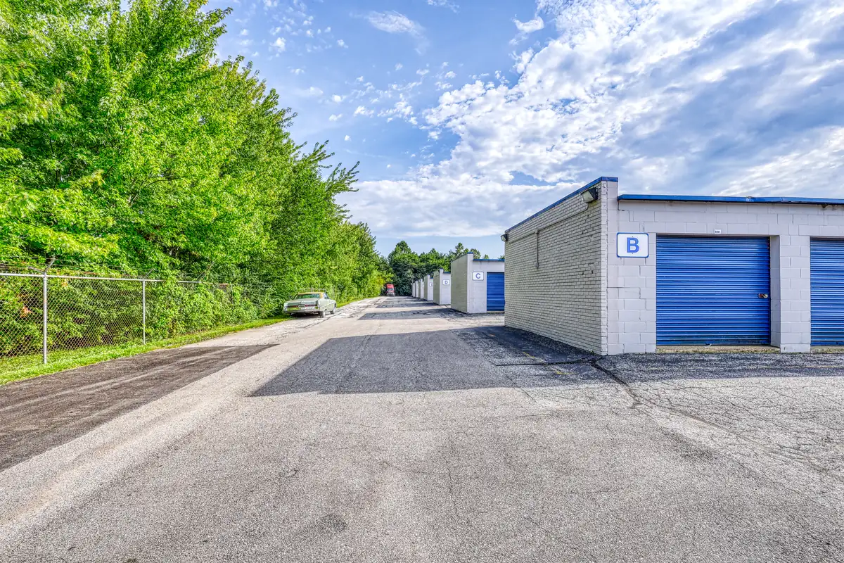 Paved drive aisle alongside a white storage building with blue drive-up doors at MyPlace Self Storage on 10th St in Indianapolis, IN.