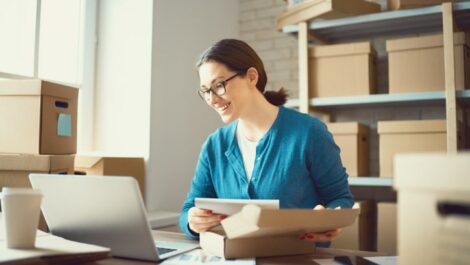 Business owner smiles while packing orders.