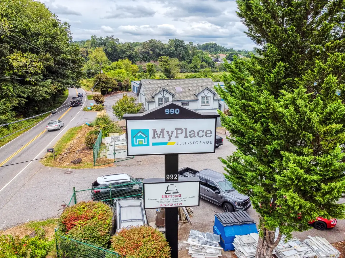 Street view of the MyPlace Self Storage monument sign surrounded by trees in Asheville, NC.