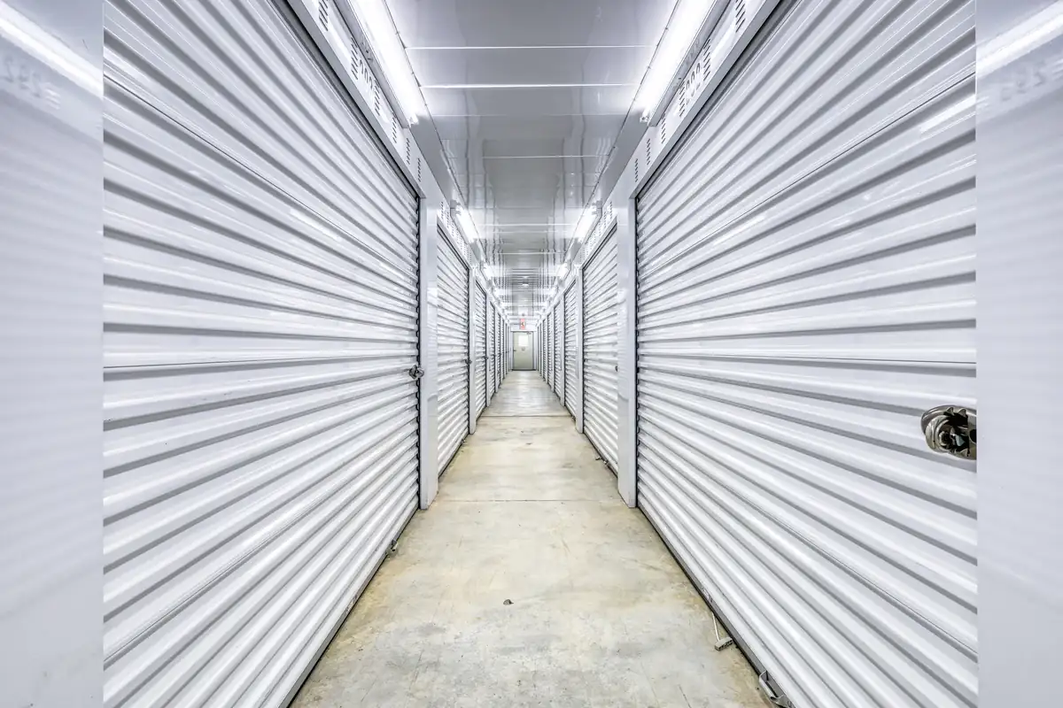 Brightly lit interior hallway lined with white doors for climate-controlled storage units at the Cicero facility.