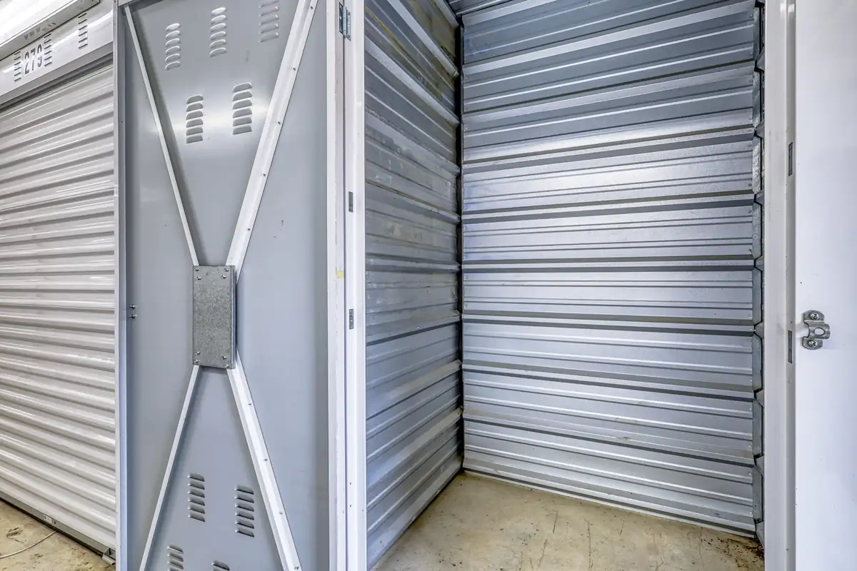Interior view looking at the closed corrugated metal door from inside a storage unit.