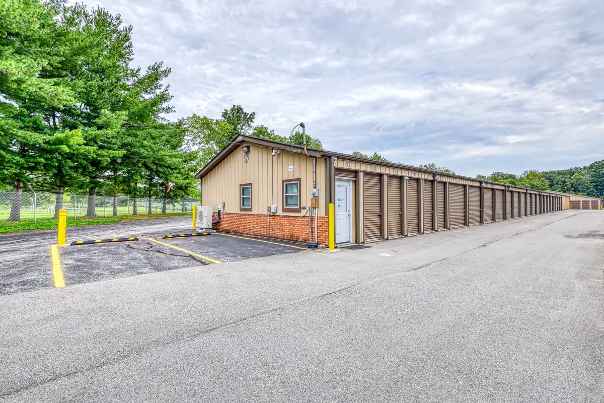 Angled exterior shot of a tan storage building featuring brown drive-up unit doors.