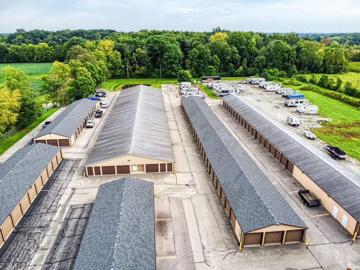 Aerial perspective of the MyPlace Self Storage Cicero facility showing multiple storage buildings and vehicle parking areas surrounded by trees.