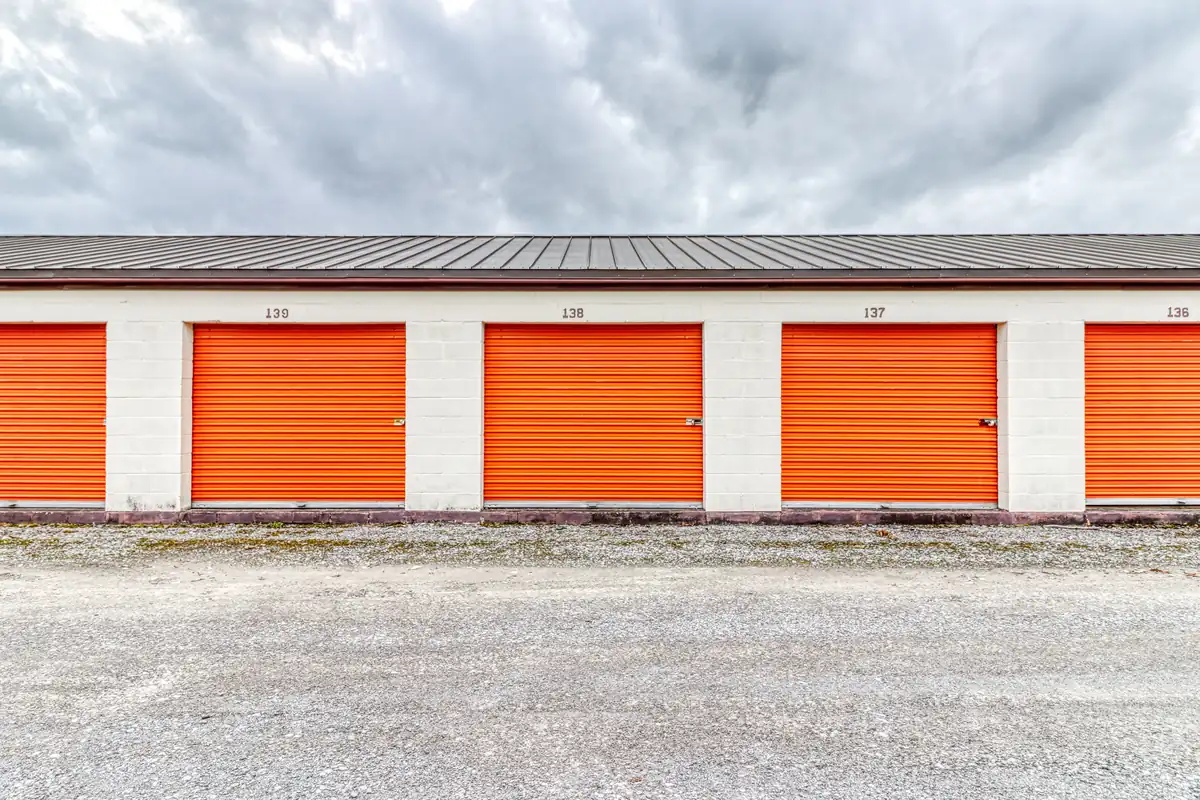 Row of orange roll-up doors on ground-level drive-up units at MyPlace Self-Storage Clarksville.