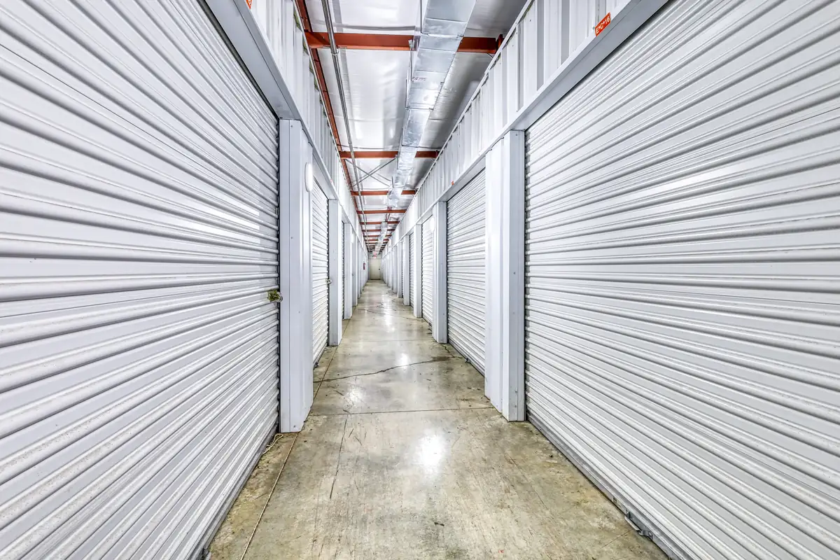 Brightly lit interior hallway lined with white doors for climate-controlled storage units in Danville, IL.