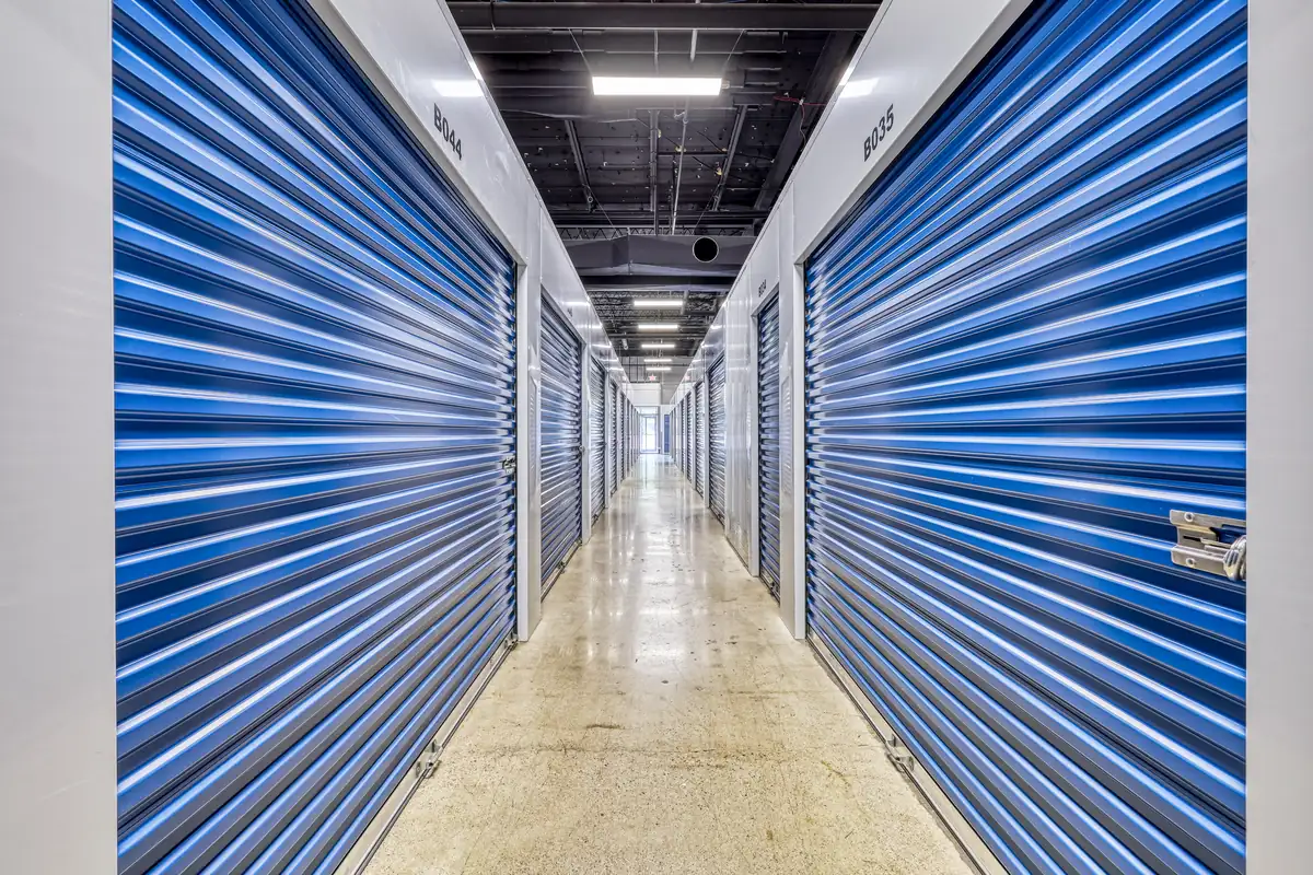 Long, clean interior corridor lined with blue doors for climate-controlled storage units.