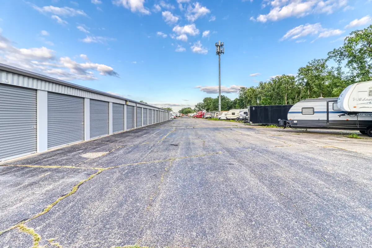 Drive aisle with units on the left, RVs and trailers parked in the lot on the right at MyPlace Self-Storage on Merriman Rd in Westland, MI.
